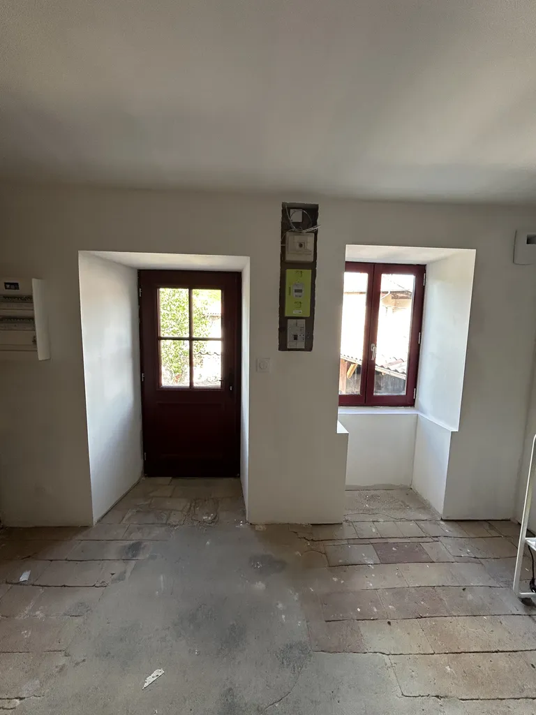 Intérieur après remplacement des fenêtres et de la porte d’entrée avec isolation thermique intérieure (ITI) et peinture dans une maison en pierre et pisé à Chiroubles (Rhône 69), améliorant le confort thermique et la luminosité