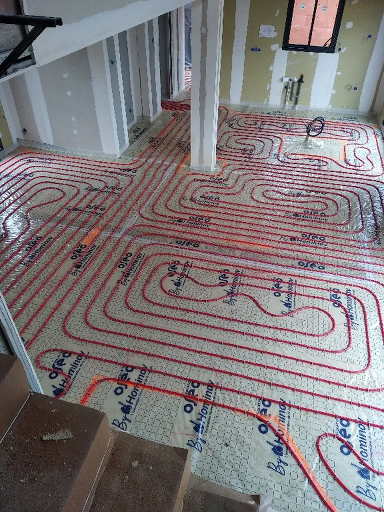Installation d'une pompe à chaleur air/eau Daikin Altherma avec plancher chauffant hydraulique pour une construction neuve à Saint-Étienne-les-Orgues dans les Alpes-de-Haute-Provence (04)