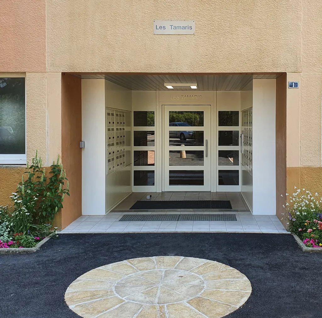 Porte de hall inox sur pivot pour copropriétés avec boîtes aux lettres et interphone