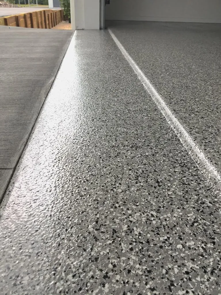 Mise en œuvre d’un revêtement polyaspartique avec paillettes PVC décoratives pour sol de garage résidentiel haut de gamme situé à Toulouse, à proximité immédiate de L’Union