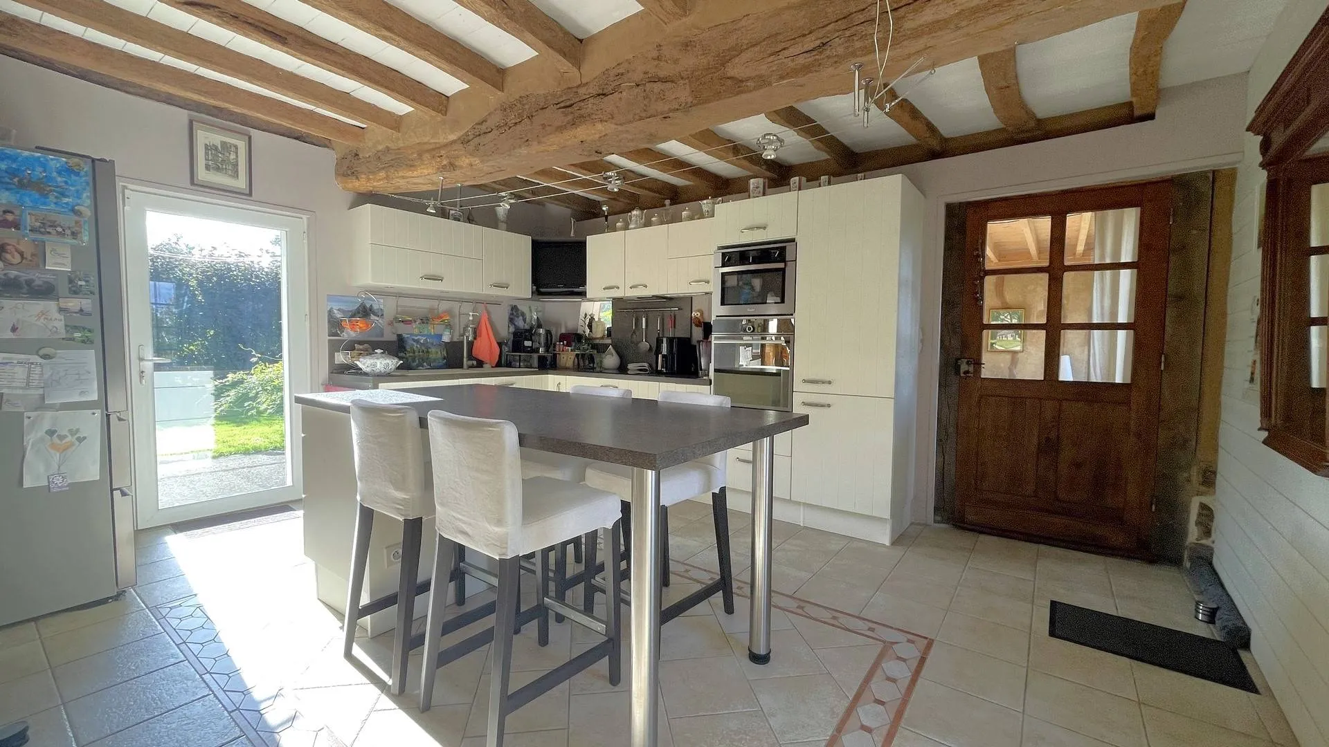 Propriété avec poêle à bois et cheminée à vendre : Le rez-de-chaussée de la maison principale offre un salon avec cheminée d’époque et insert tubé, ainsi qu’une salle à manger équipée d’un poêle à bois.