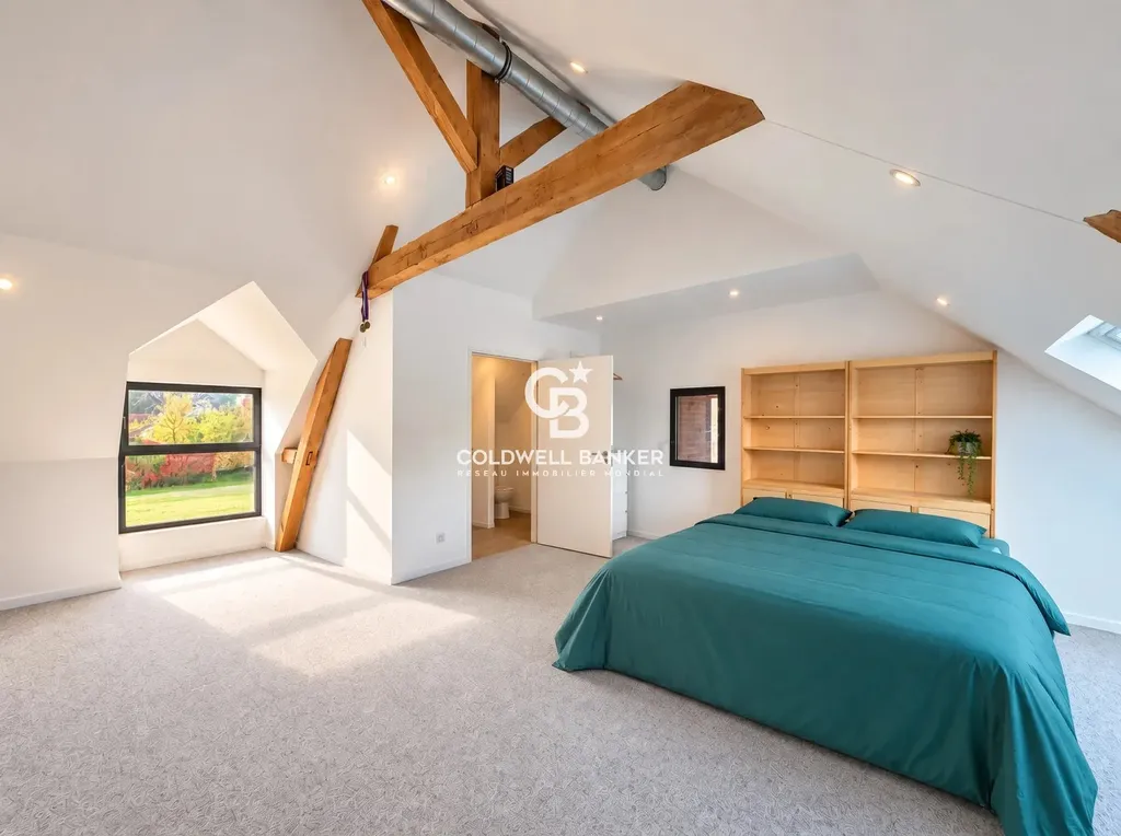 Grande chambre sous charpente apparente avec sanitaires attenants, domaine d’hébergement de groupe près du Mans