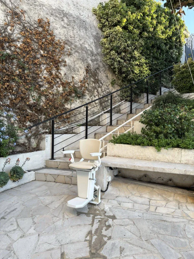 Ce fauteuil monte escalier OTOLIFT TWO spécifique pour l'extérieur installé à Marseille dans un escalier tournant n'attend que son passager
