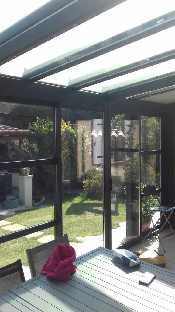Pose d'une véranda en aluminium de marque Technal de couleur noire à Simiane