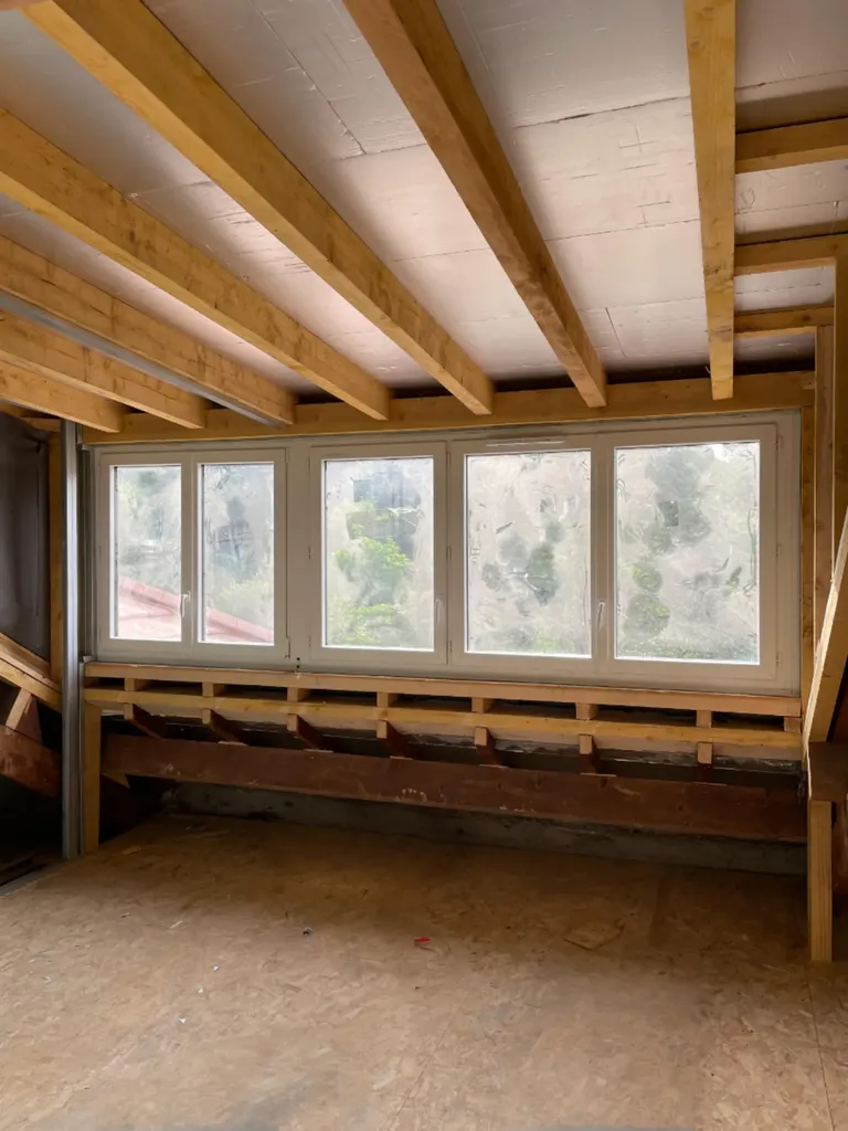 Vue intérieure d’une lucarne jacobine sur mesure, conçue lors de la surélévation à Saint-Didier-au-Mont-d’Or pour optimiser la hauteur sous plafond et la luminosité