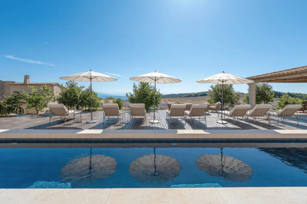 The heated swimming pool and its terrace with views of the lavender fields of Domaine Château du Boisamps de lavande du Domaine Château du Bois