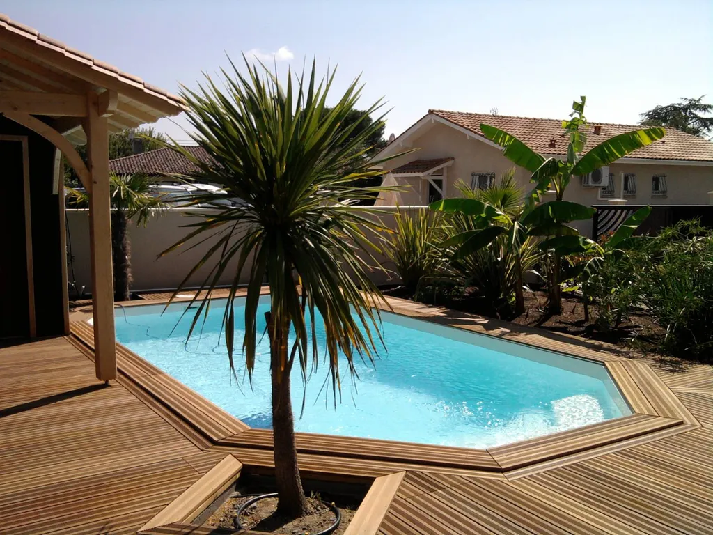 Piscine avec terrasse planchées et palmiers