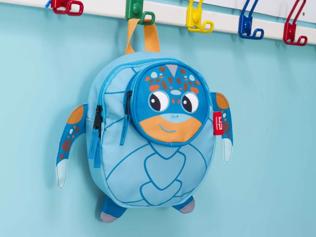 photographe maroquinerie nature morte sac goûter sur porte manteau mur bleu