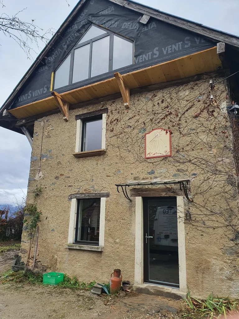 Installation à Vaulnavey de châssis aluminium de fabrication française en RAL 8019, dont un superbe ensemble vitré triangulaire réalisé sur mesure sous le pignon