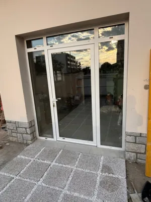 Installation d’une porte d’entrée vitrée en aluminium blanc avec imposte fixe pour local professionnel à Toulouse