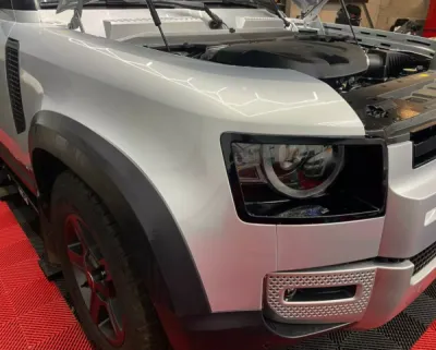 Pose de protection PPF XPEL transparente pour ce Land Rover Defender gris à Saint-Etienne : pare choc avant, capot, ailes avant, portes, ailes arrière
