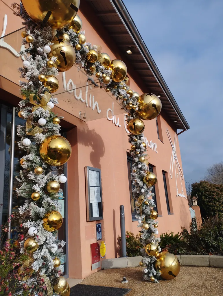 Décoration de Noël du restaurant « le Moulin du Gastronome » avec guirlandes artificielles garnies de boules or et blanches de différentes tailles et lumières scintillantes à Charnay-lès-Mâcon
