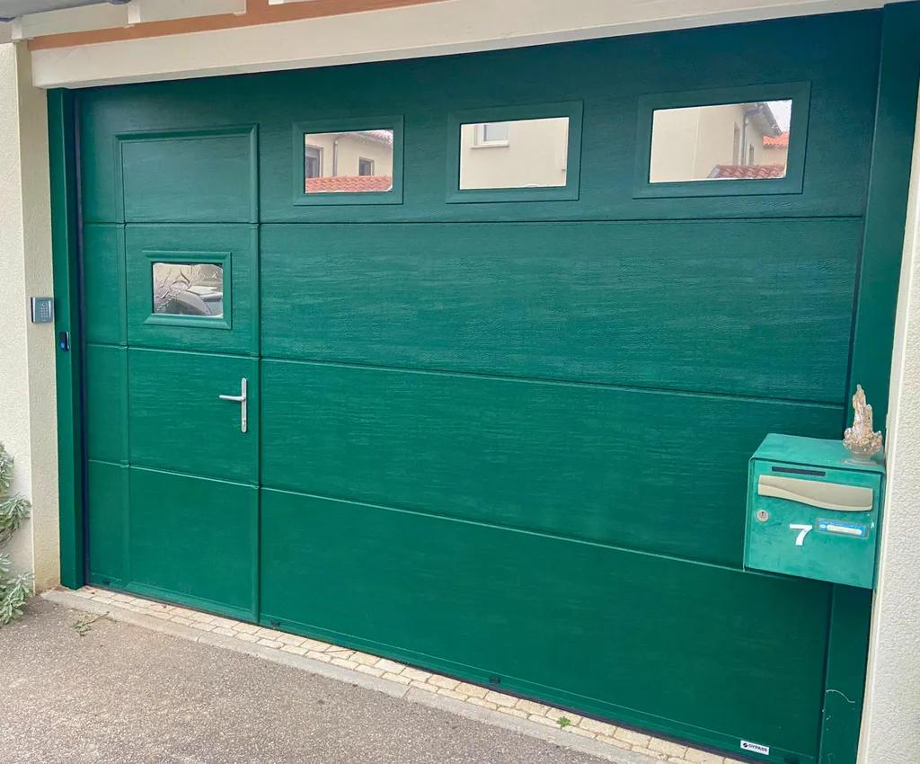 Pose d'une porte de garage motorisée GYPASS vert mousse avec portillon sécurisé et hublots à Riorges près de Roanne (Loire)