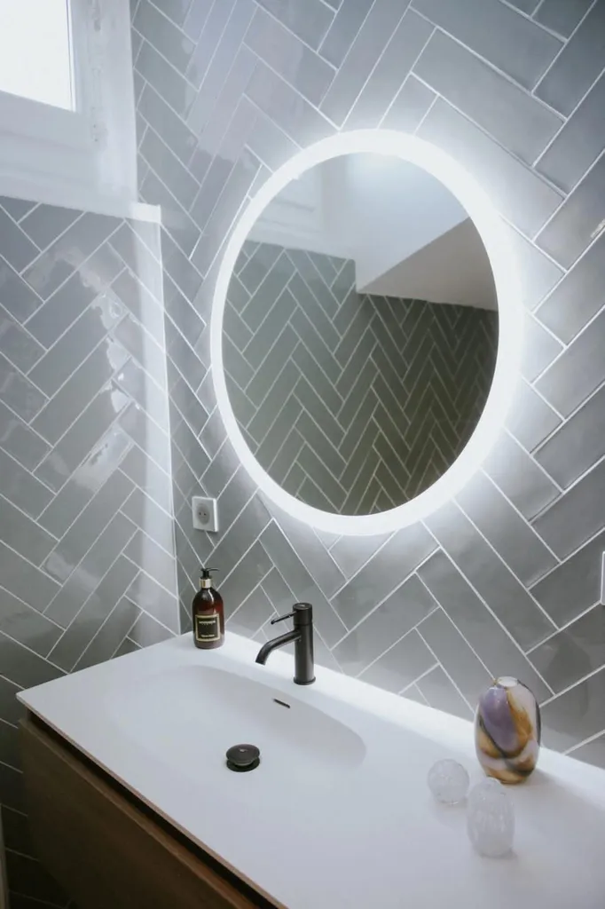 Salle de bain impeccable après une remise en état de l’habitation avec nettoyage des surfaces et du miroir