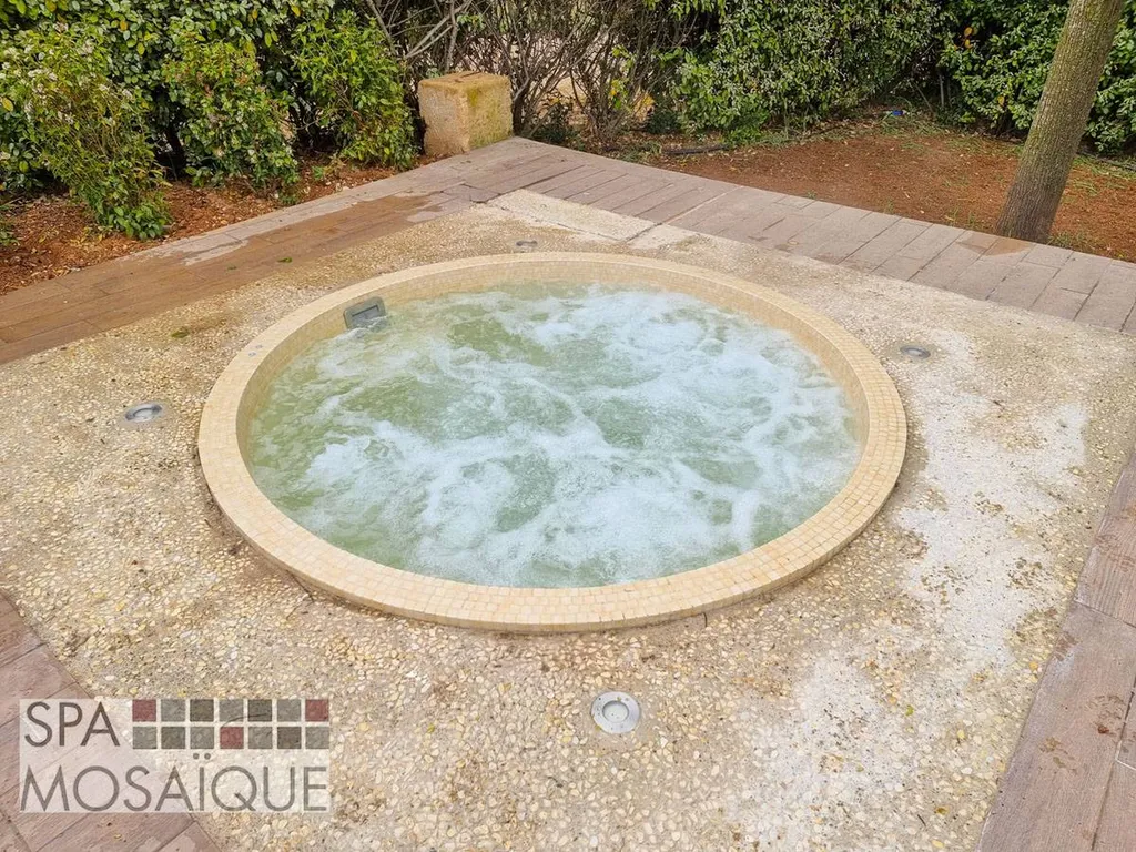 Un spa mosaïque carrelé encastré dans une terrasse en béton à Aix-en-Provence
