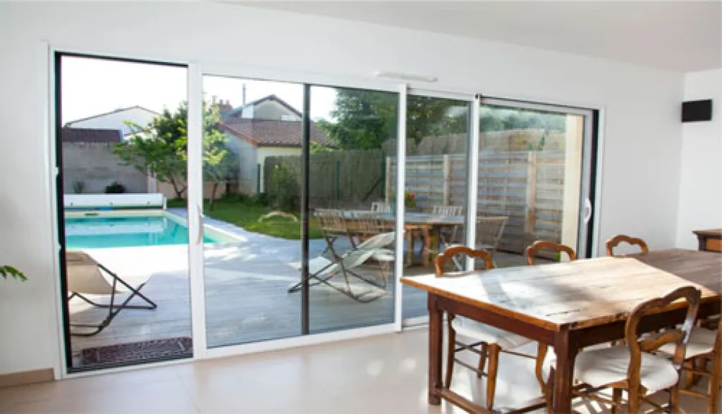 Coulissant en alu Novaltuce sécurisé avec grandes surfaces vitrées, bouclier thermique PVC et une totale liberté des couleurs à l'intérieur et à l'extérieur