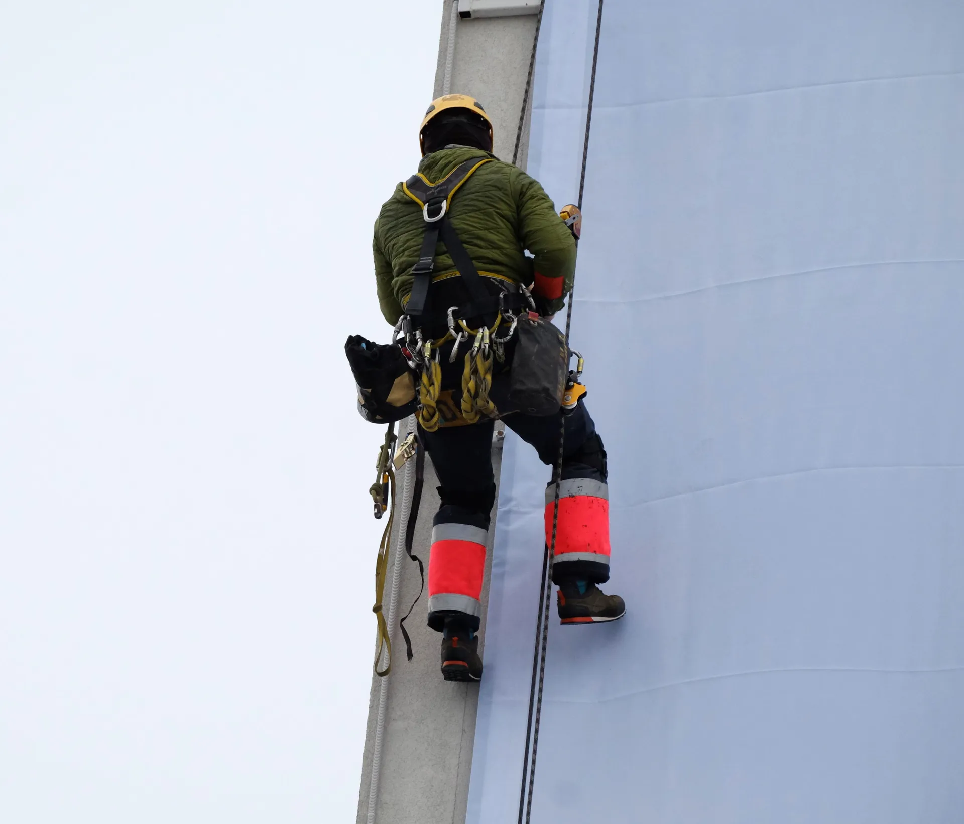 Cordiste intervenant sur une façade en travaux d'accès difficile, couvert en responsabilité civile et décennale par Covassur, à Grenoble et en France
