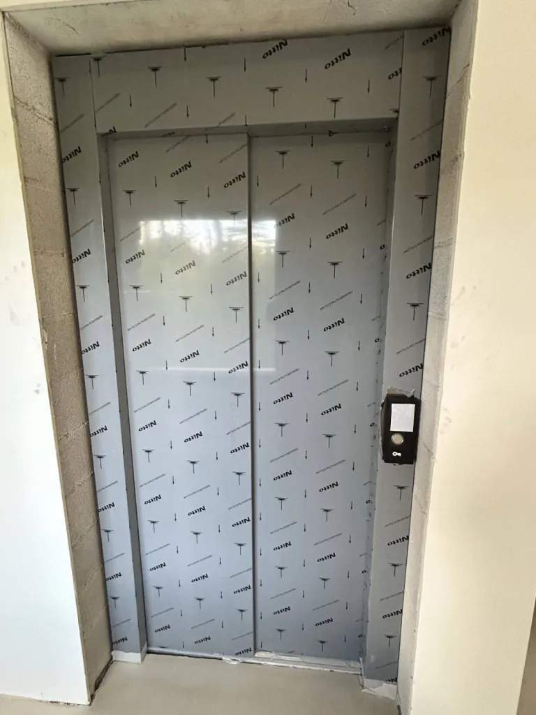 Impatients de la fin des travaux pour ôter la protection des portes télescopiques en inox brossé de cet ascenseur de maison VIMEC ARIA près d'Aix en Provence 