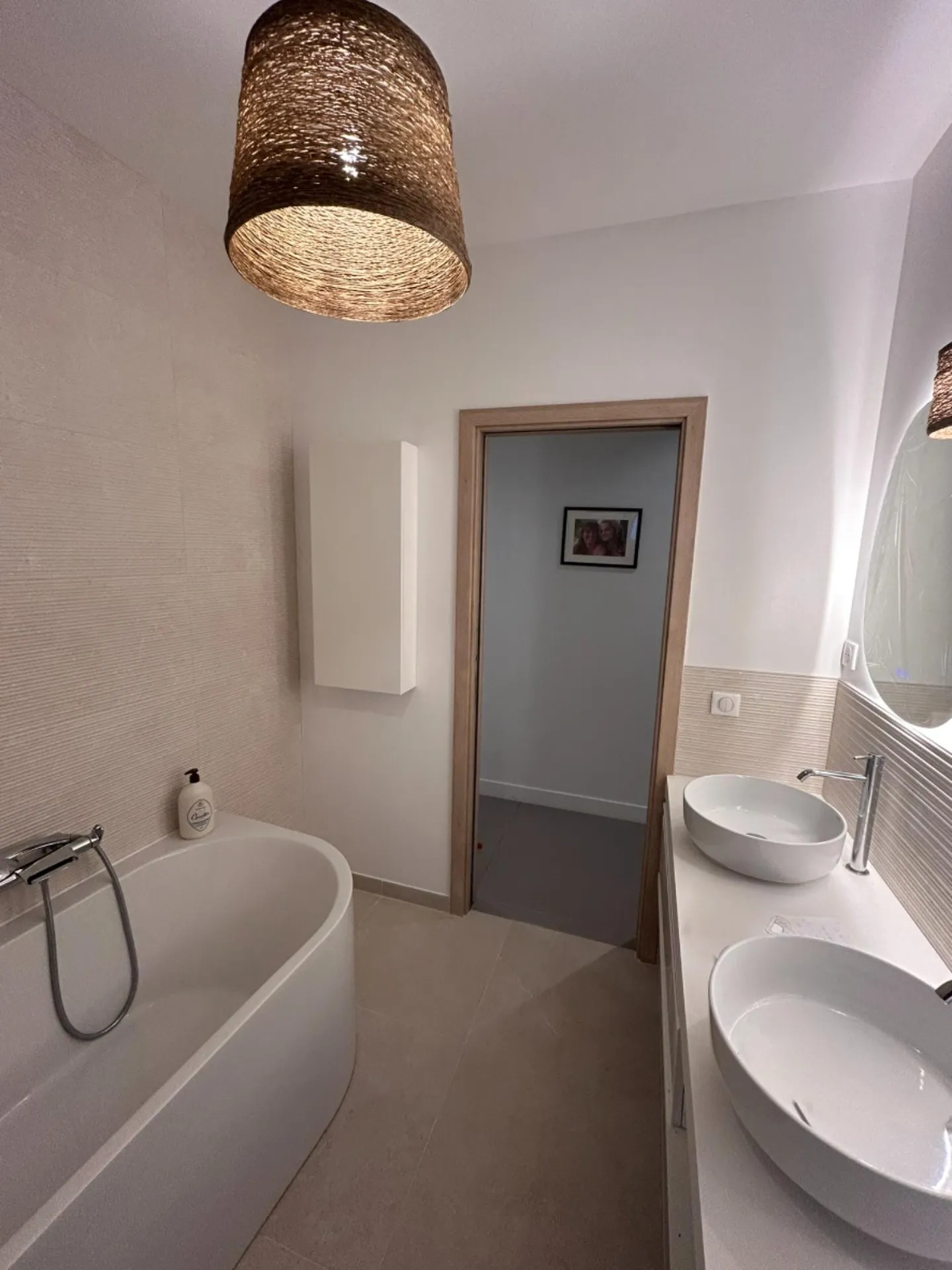 Aménagement d'un espace bain contemporain avec pose d'une baignoire et robinetterie moderne par notre entreprise RGE
