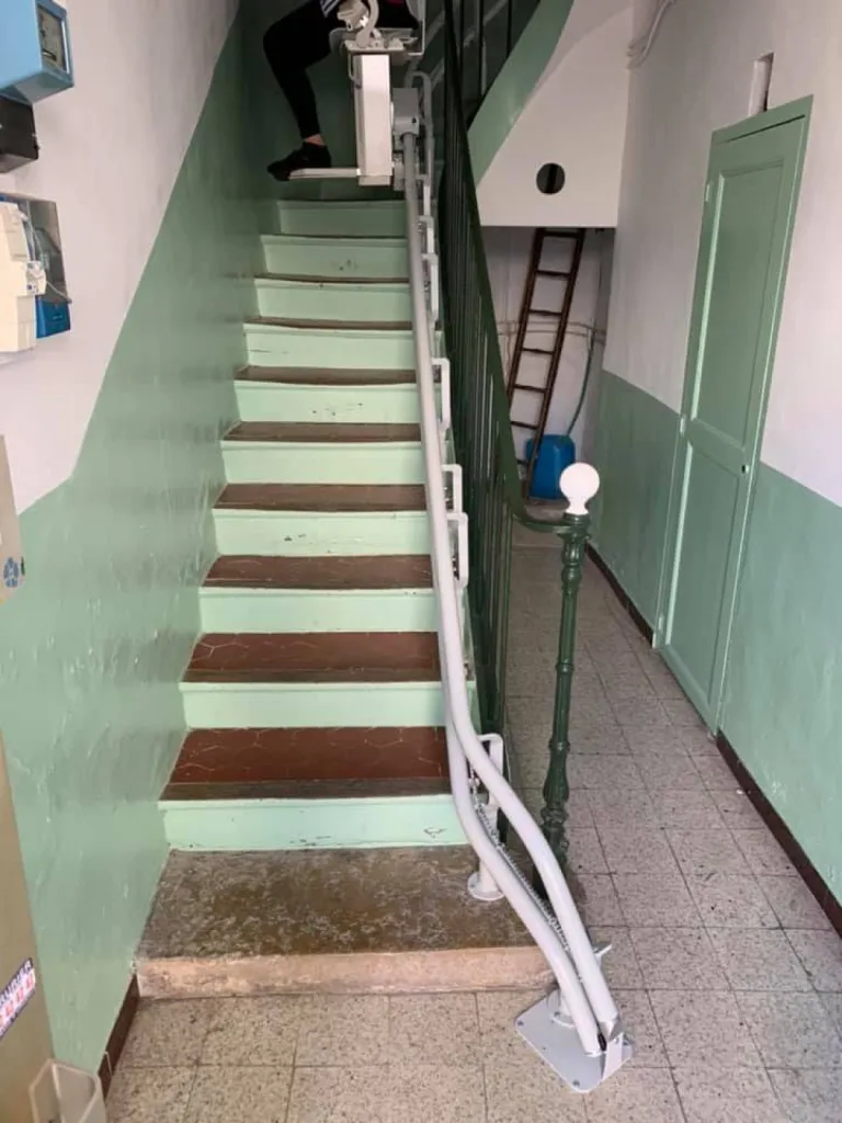 L'angle donné au départ du rail, libère l'escalier de contrainte pour ce fauteuil monte-escaliers OTOLIFT TWO dans une maison de ville à Gardanne près d'Aix en Provence