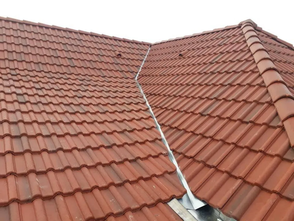 Étanchéité cheminée sur toiture tuiles plates au Chesnay avec abergement sur mesure, contre-solin et protection durable des combles