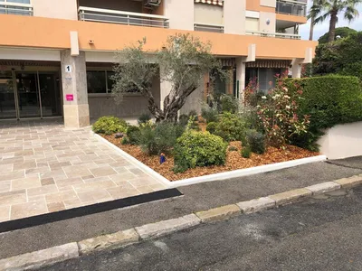 Entrée rénovée à Nice avec travertin et massifs fleuris