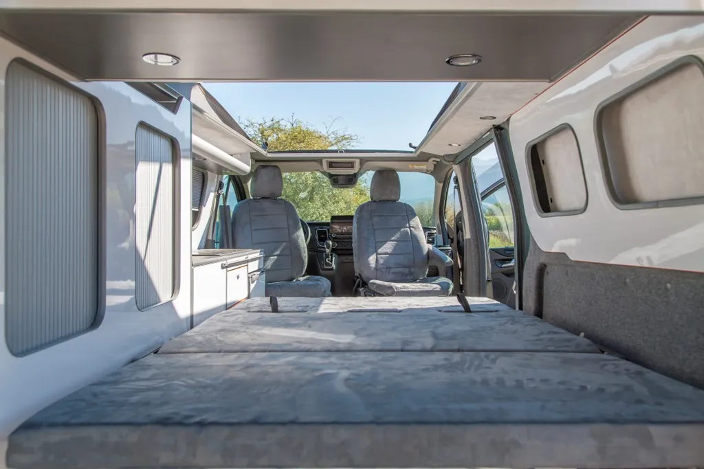 Installation de Banquette homologuée sur-mesure Ford Transit Custom L2H1 Sport modulaire avec socle blanc laqué posée à Lyon et dans le Rhône