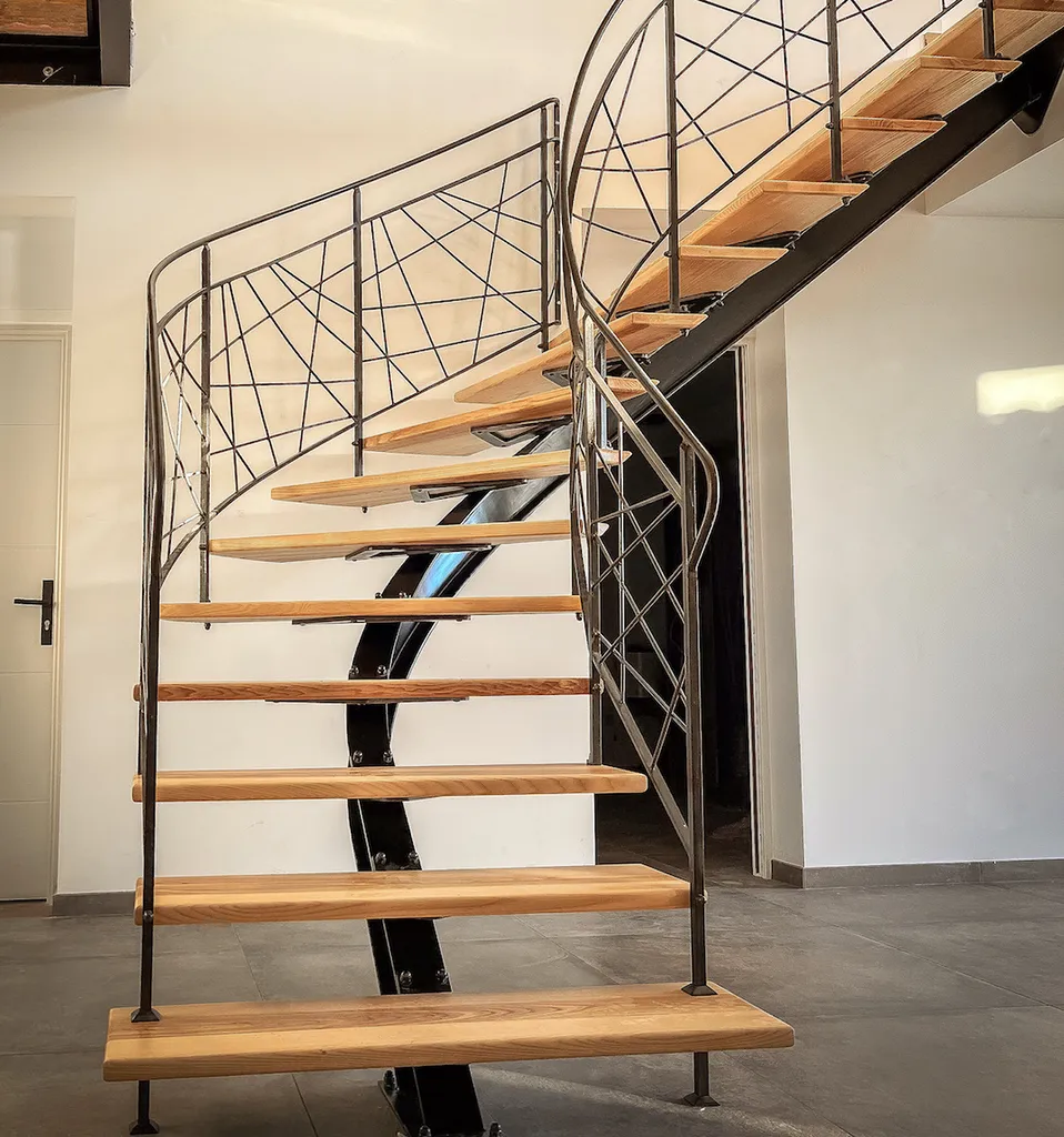 Escalier sur mesure en frêne massif avec limon central en IPN cintré et garde-corps forgé à Pradons dans le Sud Ardèche
