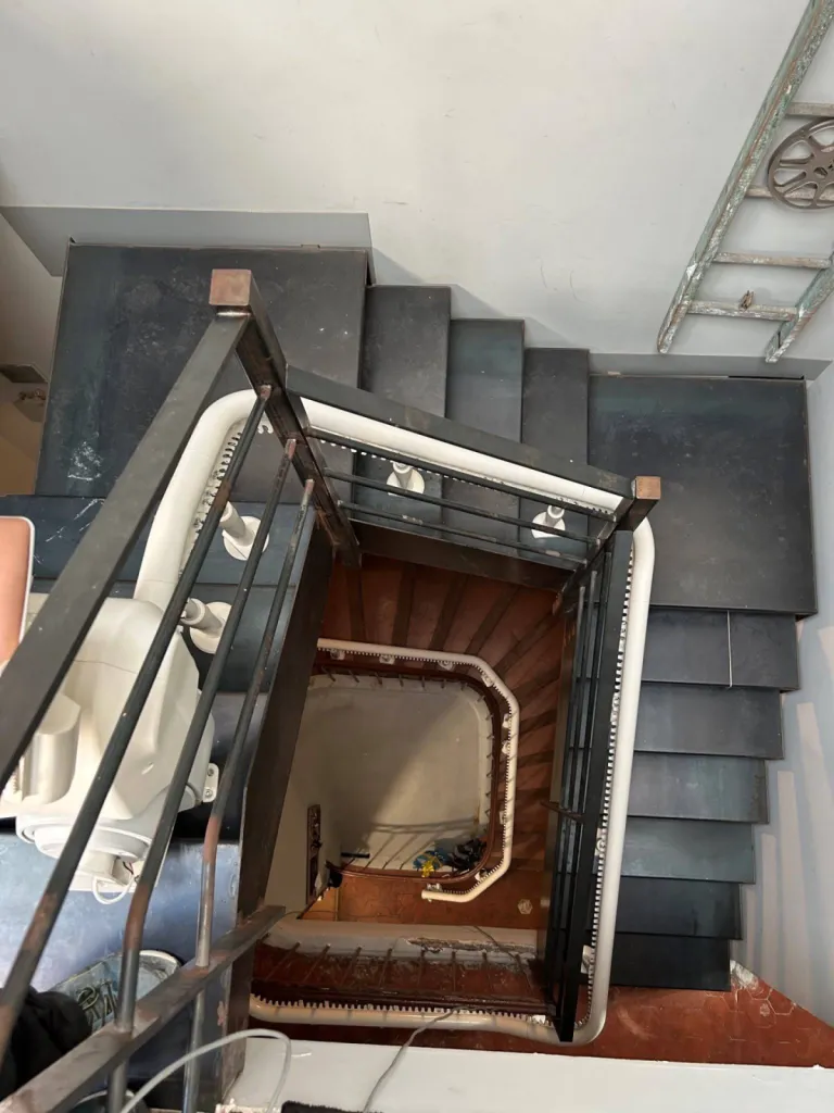 Le pivot motorisé du fauteuil monte-escalier OTOLIFT Modul'Air facilite la sortie de l'utilisateur dans cet escalier intérieur en colimaçon à Marseille