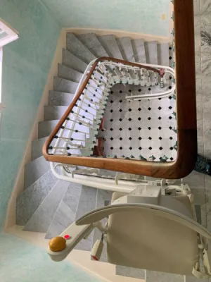 installation d'un fauteuil monte-escalier dans un escalier tournant en marbre sur Nice