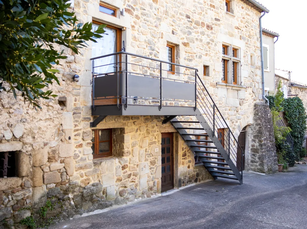 Fabrication d’un escalier extérieur en acier noir avec palier sur mesure pour façade en pierre ancienne
