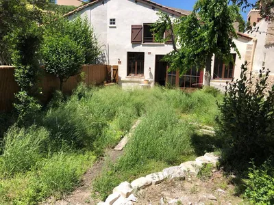 Aménagement paysager dans les alentours dès Alpilles, créant un jardin cosy et tendance avec des végétaux, fontaine et copeaux de bois