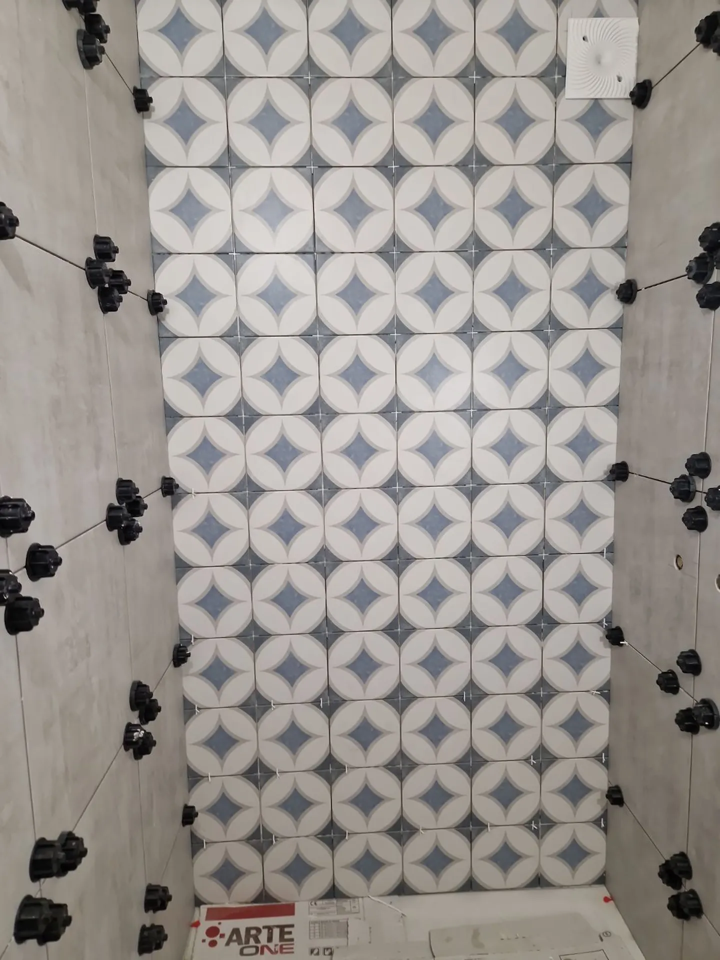 Travaux de pose de carrelage mural lors de la rénovation d’une petite salle de bain à Tassin-la-Demi-Lune près d’Écully dans l’Ouest lyonnais.