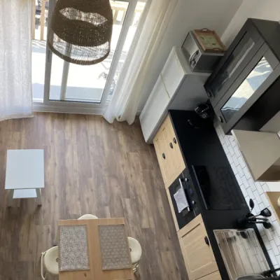 Ambiance noire, blanche et bois dans la pièce de vie principale, par l'Atelier D, architecte d'intérieur à Bordeaux
