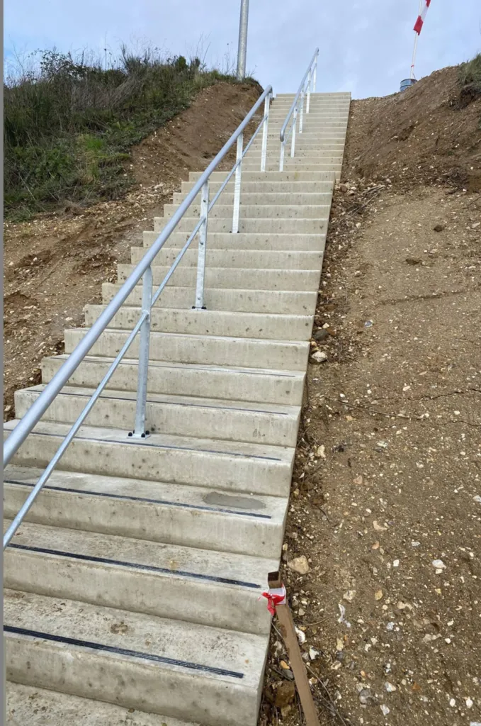 Installation d'une main courante métallique dans escalier d'accès à Cléon 76