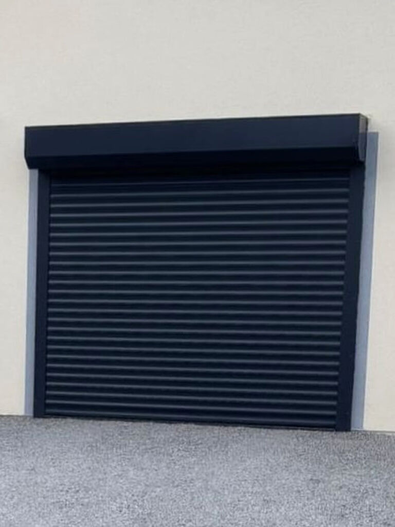 Installation d'une porte de garage enroulable LAKAK gris anthracite sur-mesure avec motorisation SOMFY, alarme et barre palpeuse à Roanne (42) par 3 Baies