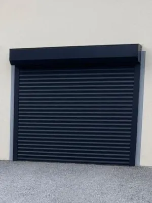 Installation d'une porte de garage enroulable LAKAK gris anthracite sur-mesure avec motorisation SOMFY, alarme et barre palpeuse à Roanne (42) par 3 Baies