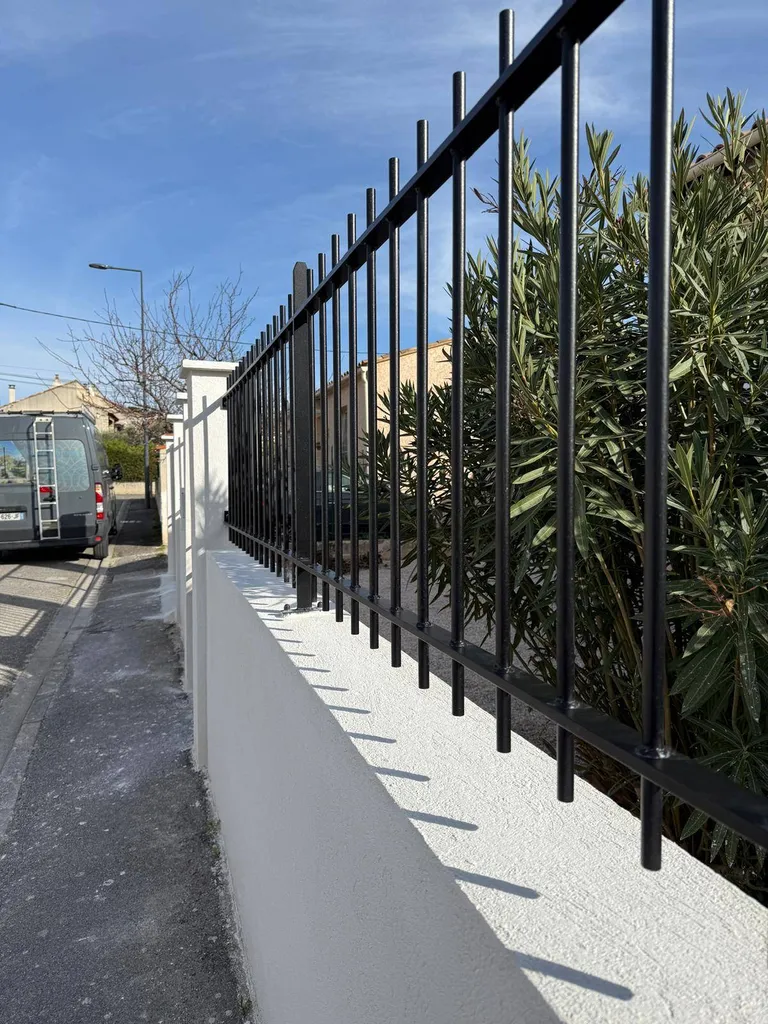 Détail de la finition et du design sur mesure d'une clôture en acier, illustrant le savoir-faire artisanal de l'Atelier du Ferronnier.