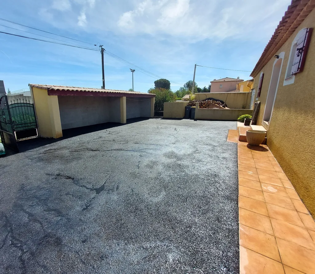 Application d'enrobé de bitume noir dans la cour d'une villa à Saint-Maximin la Sainte-Baume, dans le Var