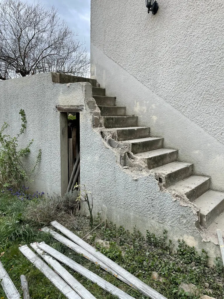 Démolition du mur en béton servant de garde-corps avant la pose d’un garde-corps inox lors de la rénovation de cet escalier extérieur à Belleville-en-Beaujolais (Rhône – 69)