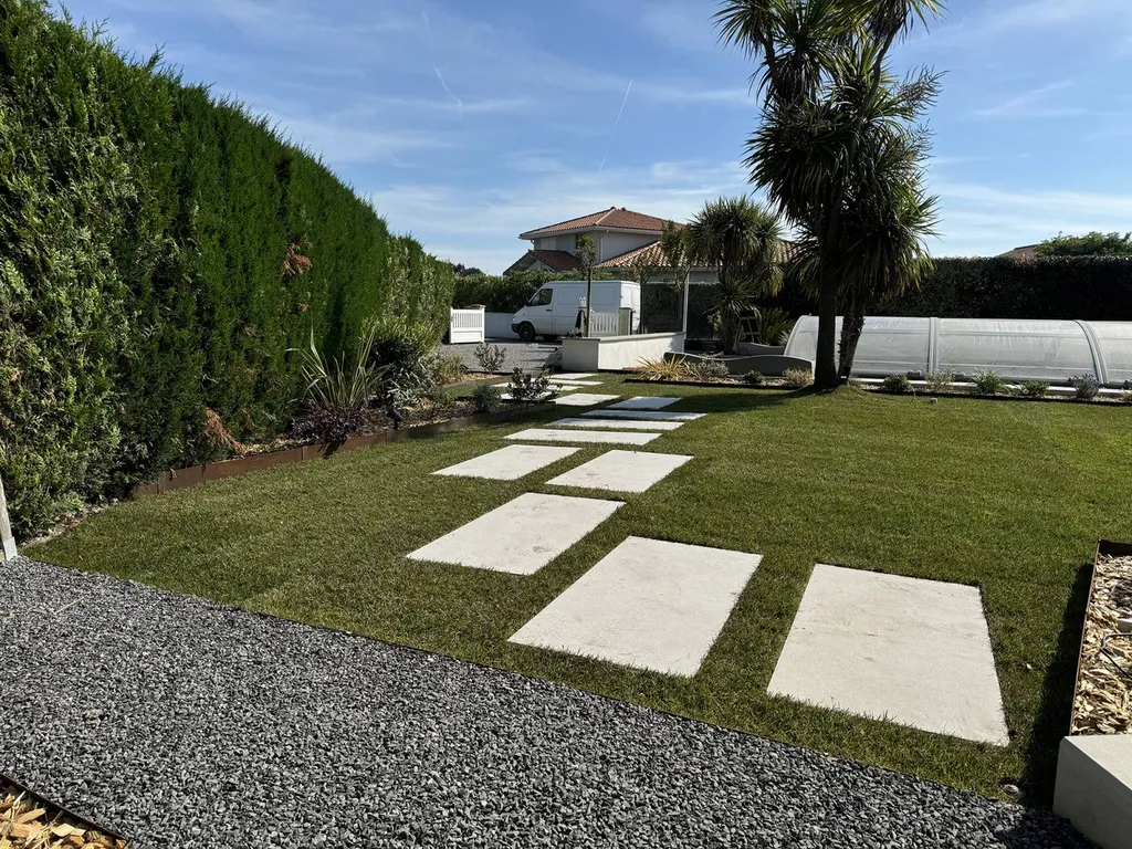 Pelouse d’un jardin changée en un espace esthétique et fonctionnel près de Bias