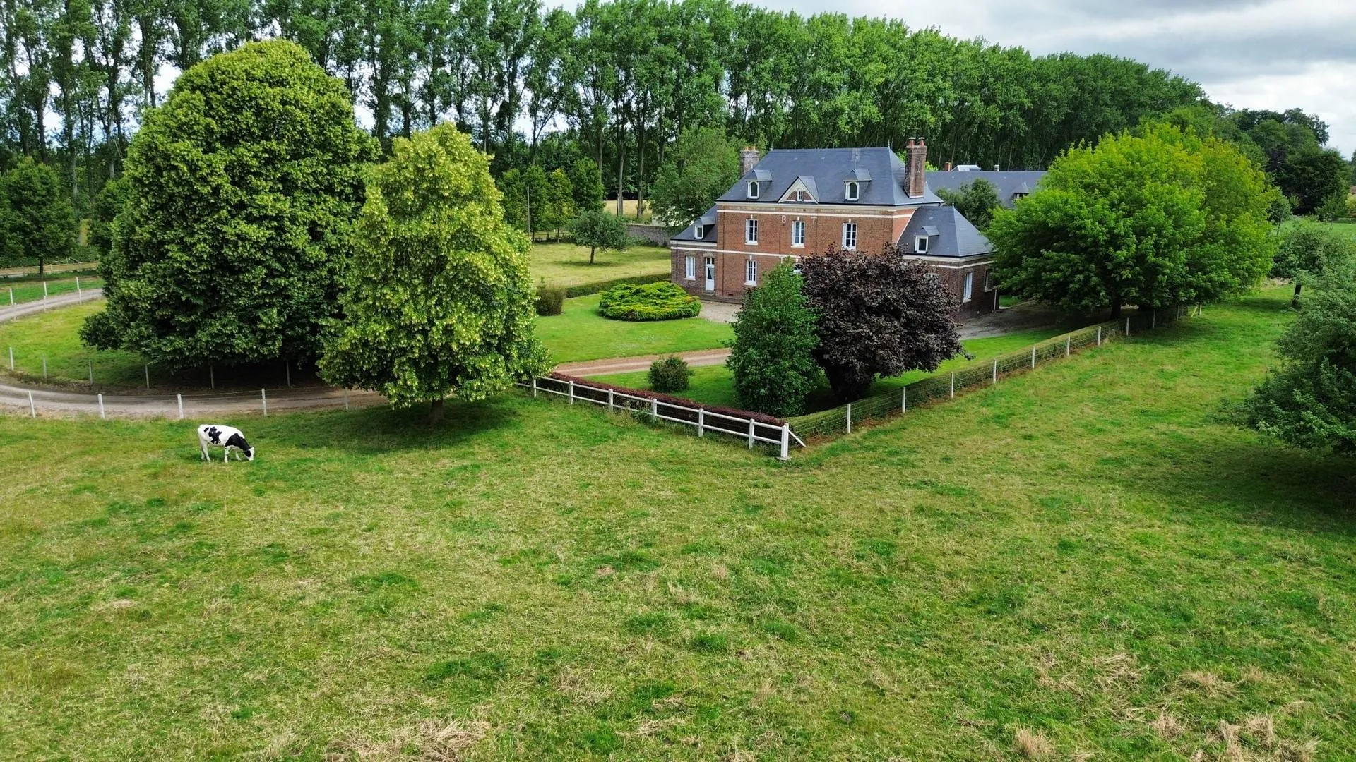 Opportunité en Normandie** : À l'extérieur, une longère utilisée comme garage et espace de stockage, un hangar semi-ouvert et une grange complètent cette propriété exceptionnelle en Normandie, parfaite pour les amoureux de la nature et les projets de