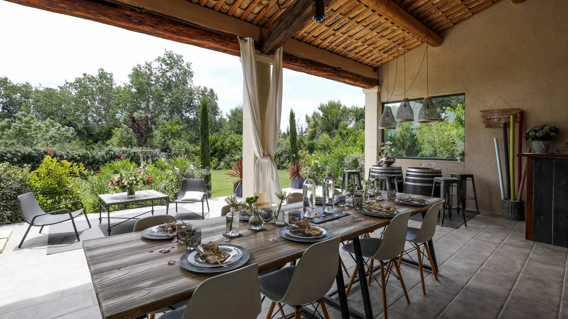 Terrasse couverte avec tuiles de récupération et charpente en bois d'une construction de maison individuelle de style traditionnel