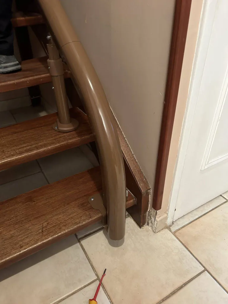 Le tournevis vous indique le départ court 1er nez de marche de ce fauteuil monte escalier OTOLIFT Modul'Air Smart en intérieur dans un escalier étroit 2/4 tournant à Marseille