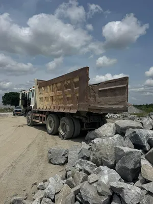 Camion-benne à proximité de blocs de roche sur la carrière BCG au Bénin, dans la zone de manutention des matériaux.