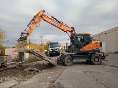 Décroutage de l'enrobé par une pelle mécanique à pneus
