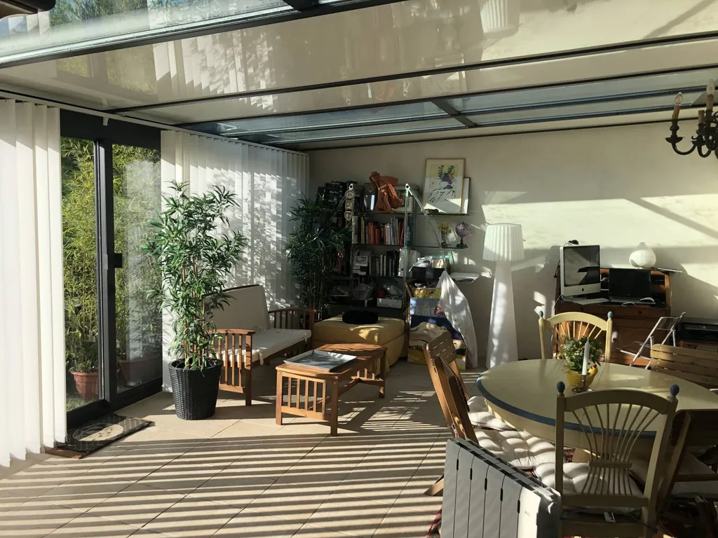 Installation de stores à bandes verticales sur la façade d'une véranda en aluminium TECHNAL à Puyricard