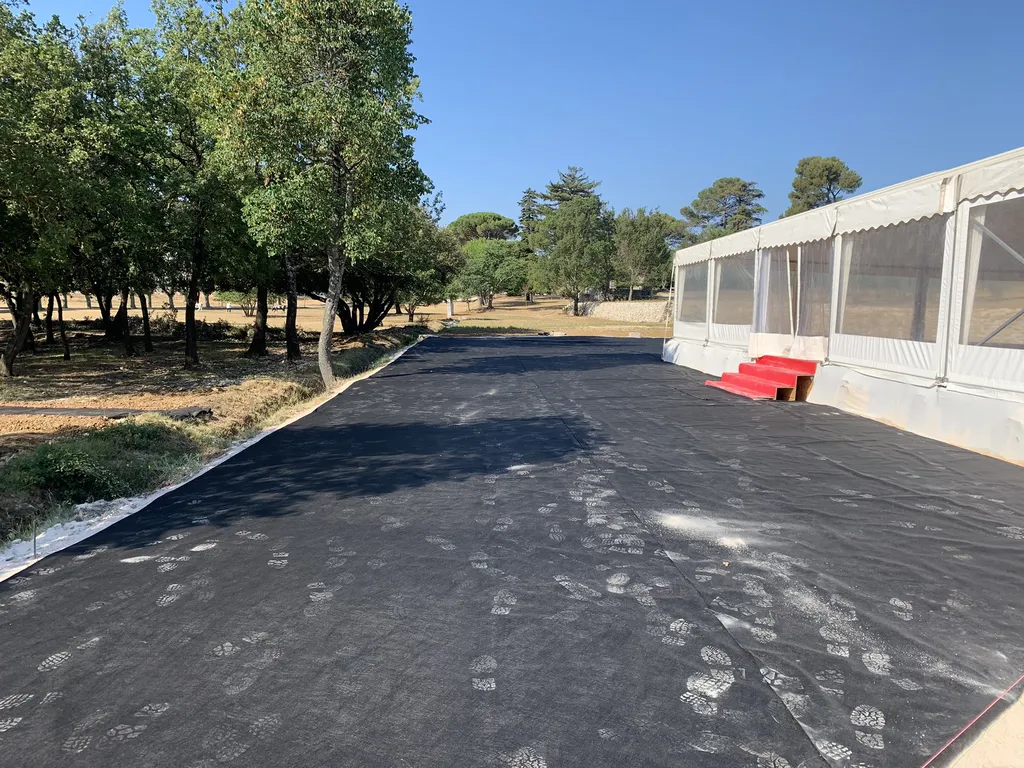 Installation complète de gazon synthétique haut de gamme autour d’un chapiteau pour réceptions et mariages à Lourmarin