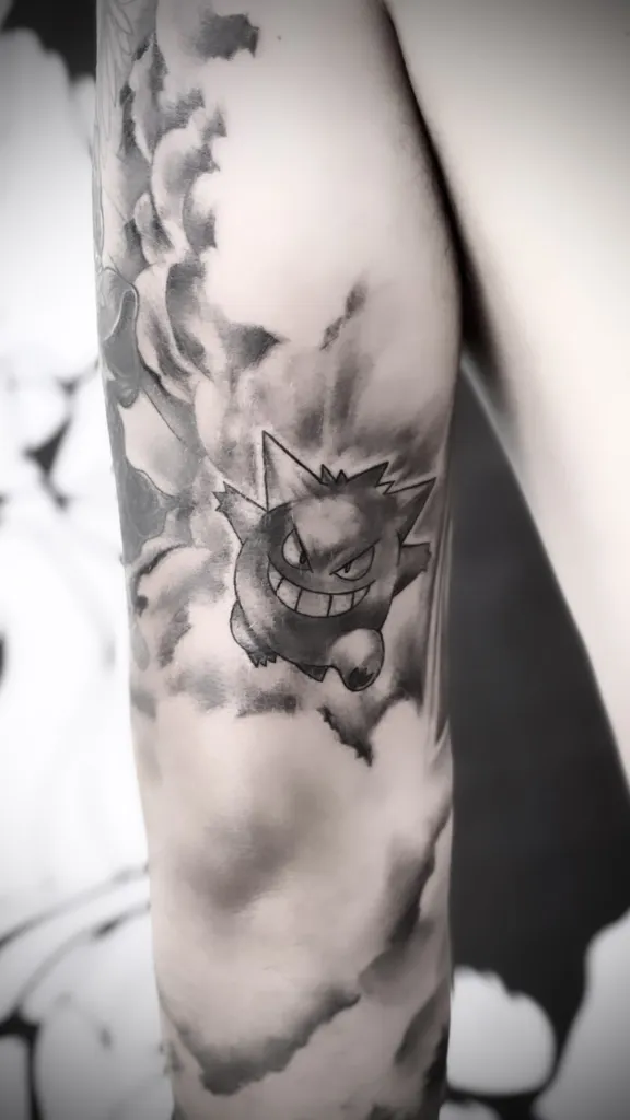 Réalisation d'un tatouage Pokémon d'Ectoplasma en nuance de gris sur le bras proche d'Annecy en Haute Savoie