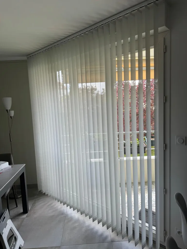 Pose d’un store à bandes verticales Bandalux sur la baie vitrée du salon d'un appartement à Bron